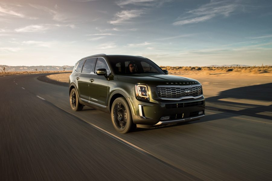 a Kia Telluride SUV driving at speed on a desert highway