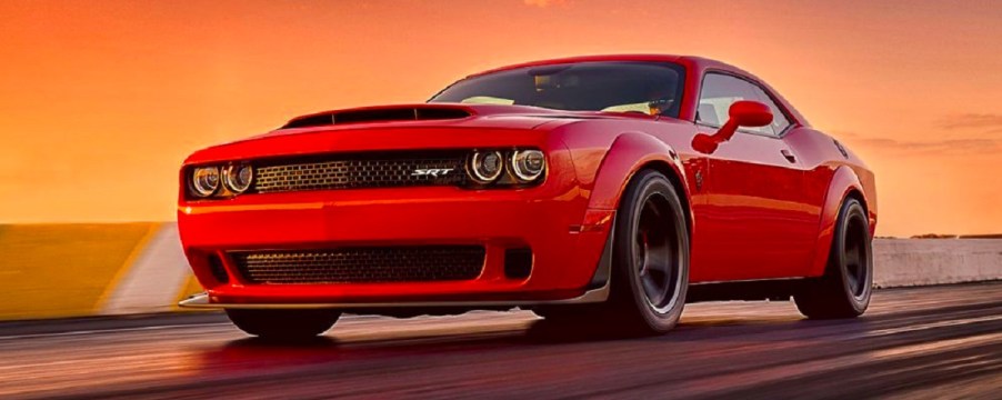 A red 2018 Dodge Challenger Demon against an orange setting sun.