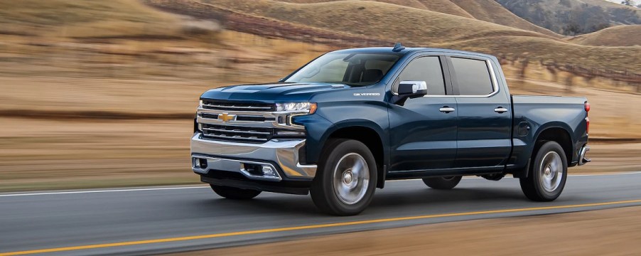 A blue 2021 Chevy Silverado races down the highway.