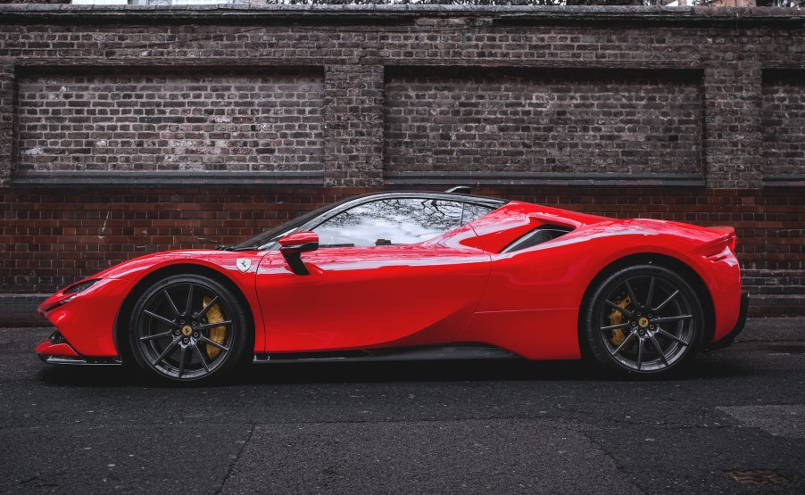 A red Ferrari SF90 Stradale hypercar parked in front of a red-brick wall in Mayfair, London, in April 2021