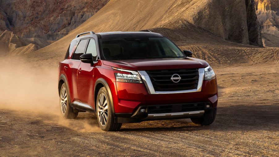 A red 2022 Nissan Pathfinder on dirt road