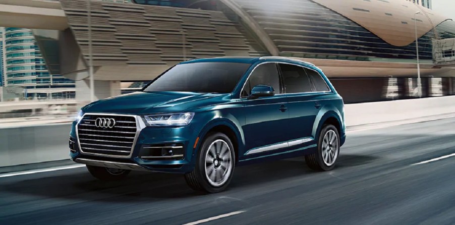 A blue 2021 Audi Q7 driving down a highway.