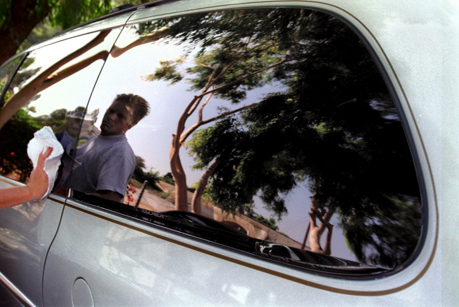 Teenager Colby McGehee details a silver minivan in August 1998