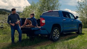 A blue 2021 Toyota Tundra with a child sitting in the back.