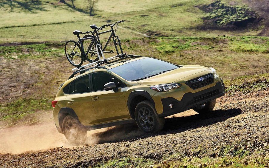 A gold 2021 Subaru Crosstrek with bicycles on top.