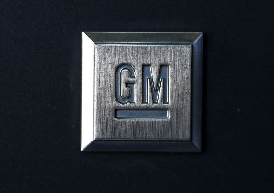 A charcoal grey plaque with the General Motors logo, GM, on it against a black background.