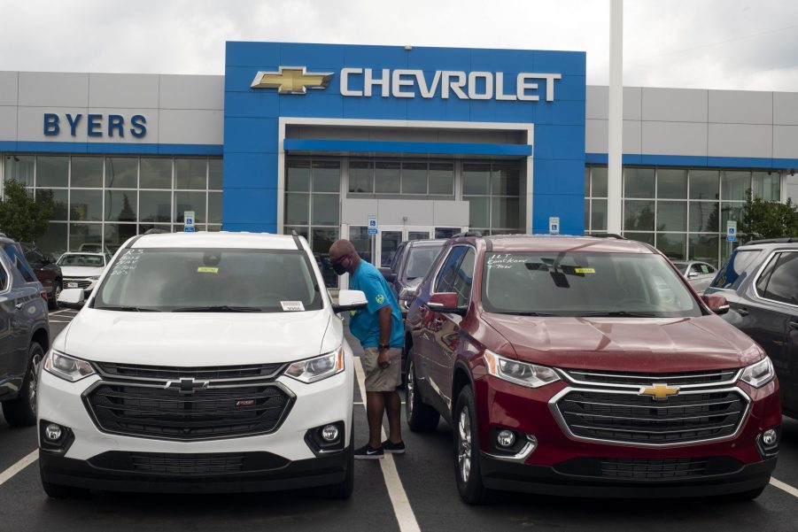 A man looks in the window of a used Chevrolet