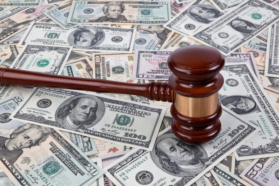 An auction gavel lies on a stack of cash