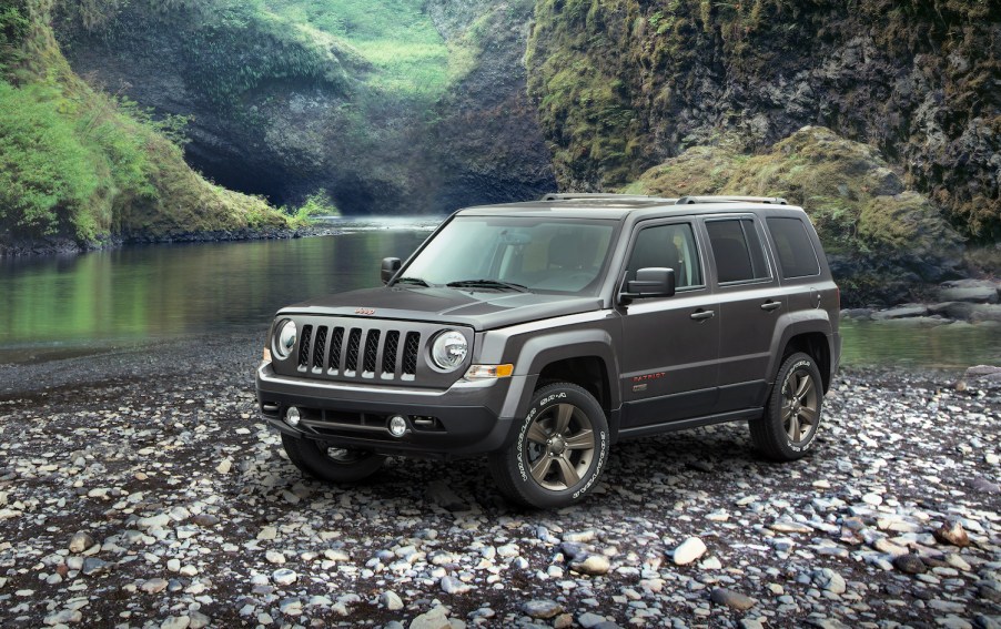 A grey 2016 Jeep Patriot parked along a river bed, the 2016 Patriot is one of the worst used cars you can buy