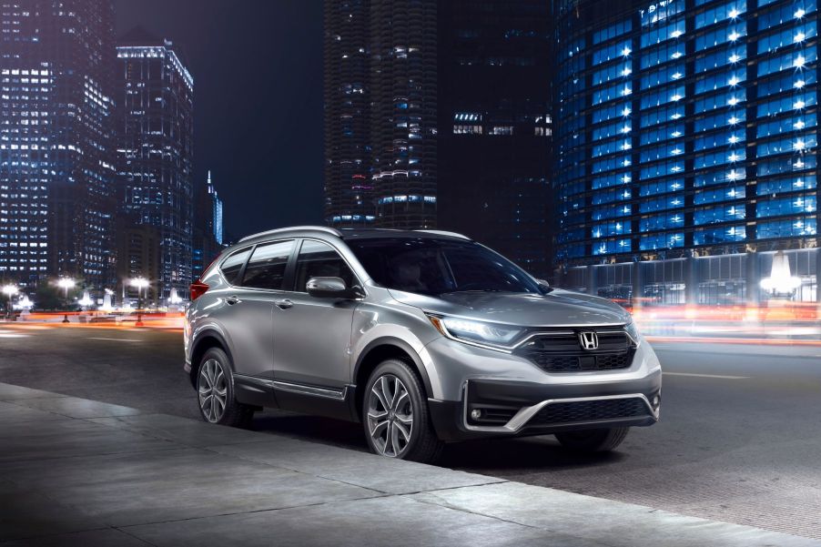 The 2022 Honda CR-V Touring SUV parked on the side of a city street at night