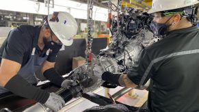 Two Toyota factory workers manufacturing the Tundra's powertrain in the U.S.A.