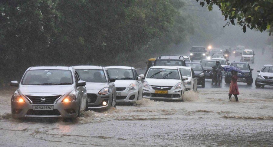 Cars cross a waterlogged area.