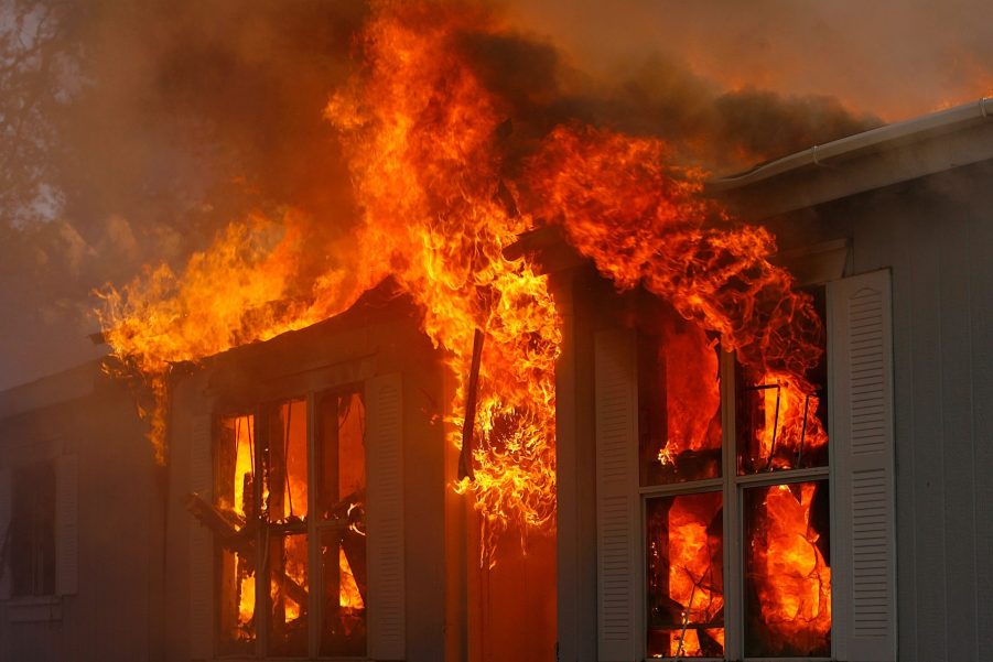 Flames pour from the window of a burning building