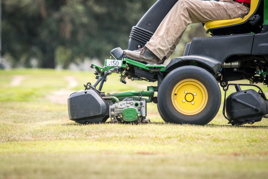 A man operating a riding lawn mower to cut grass in Tifton, Georgia