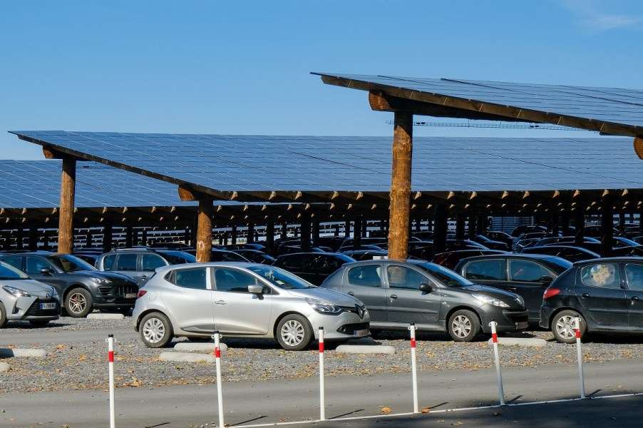 Cars in a parking lot covered by solar panels.