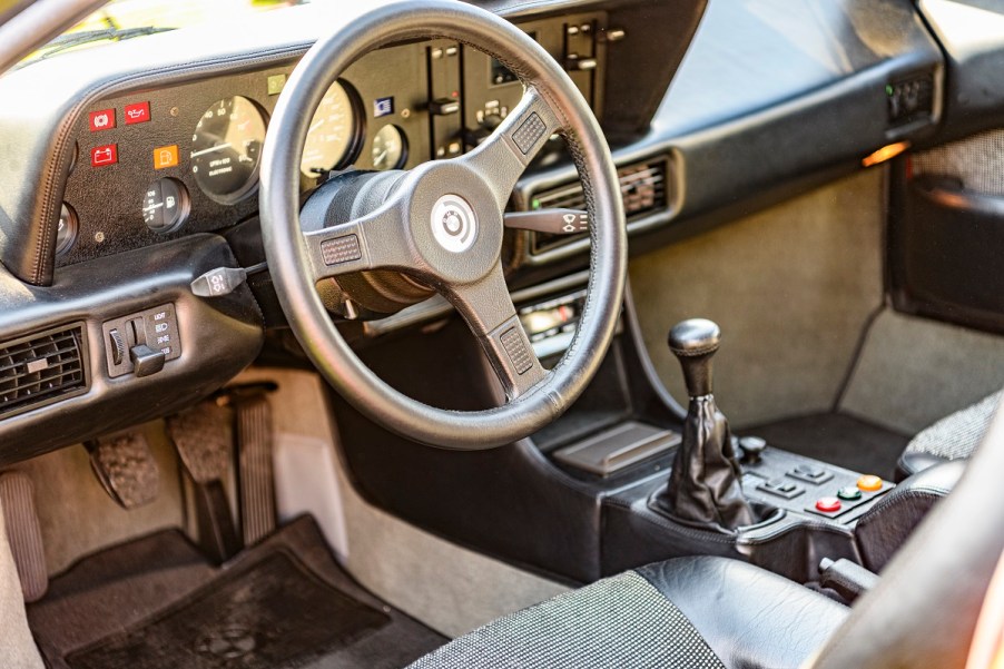 The inside of a car including a stick shift.