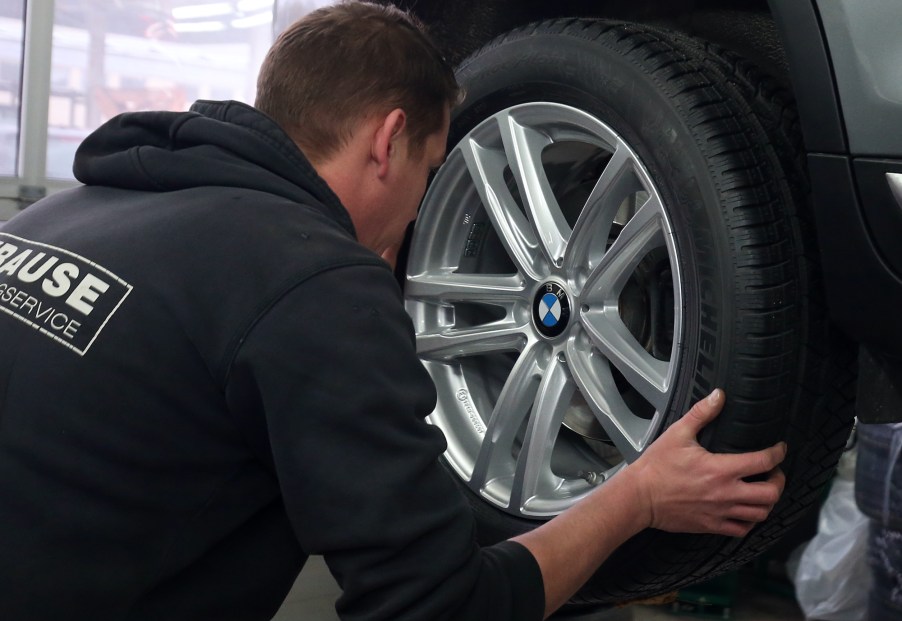 A tire shop mechanic rotate tires