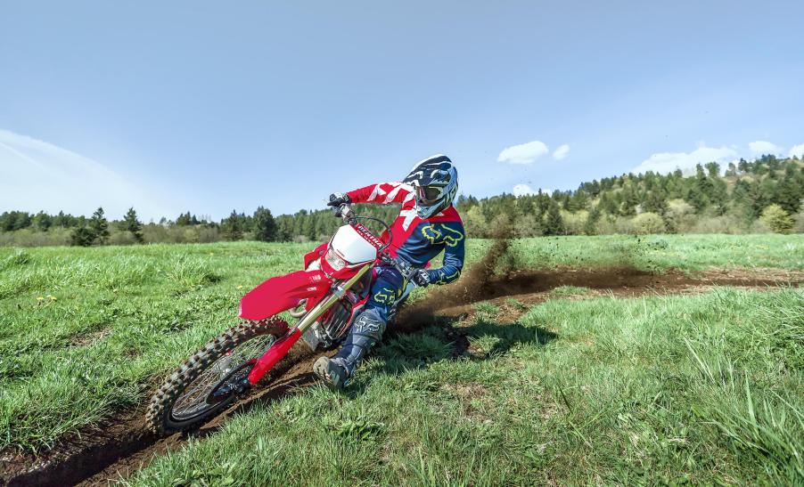 the Honda CRF450X blazing a trail in a green field