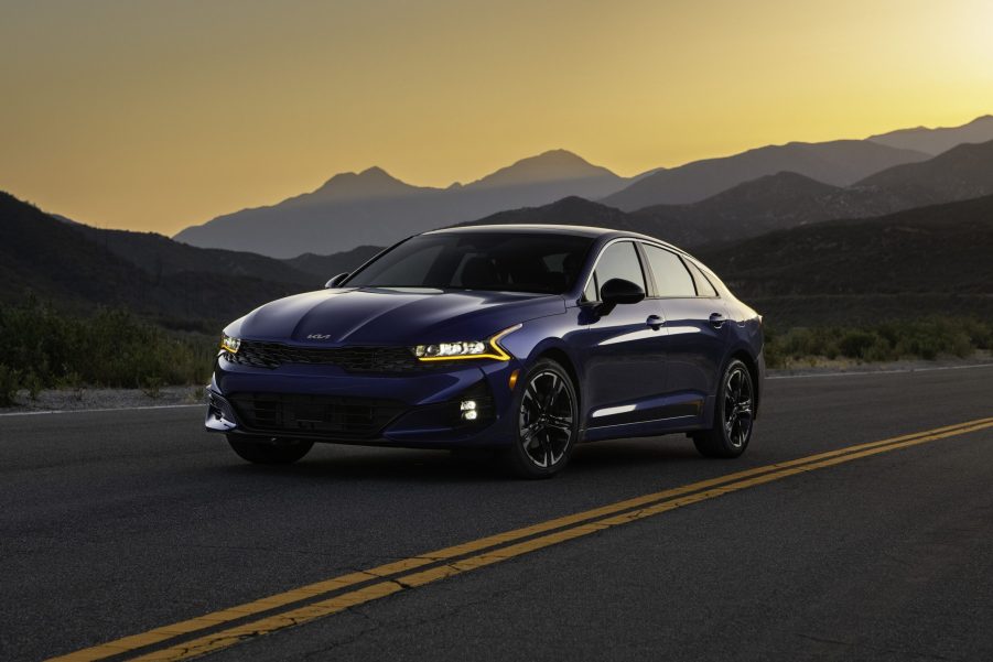 The 2022 Kia K5, shot from the front 3/5 at sunset with dark blue paint