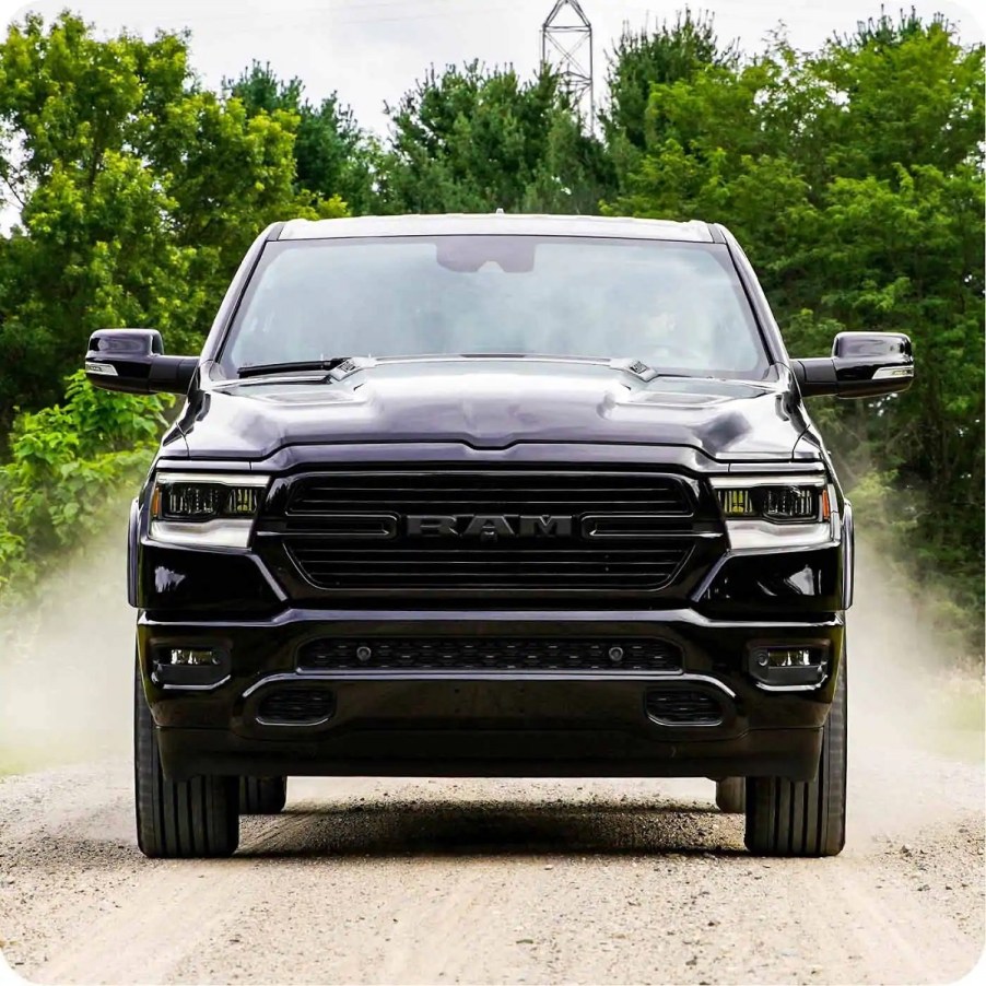 A black 2021 Ram 1500 driving down a dirt road.