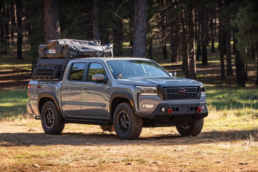 Gray 2022 Nissan Frontier driving by a forest