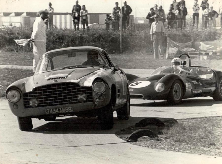 Vintage Jaguar XK140 barn find in a vintage photo racing a Ferrari