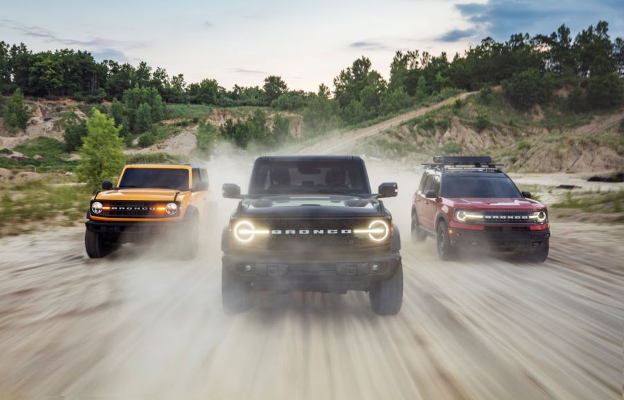 Three 2021 Ford Bronco SUVs driving on a gravel road