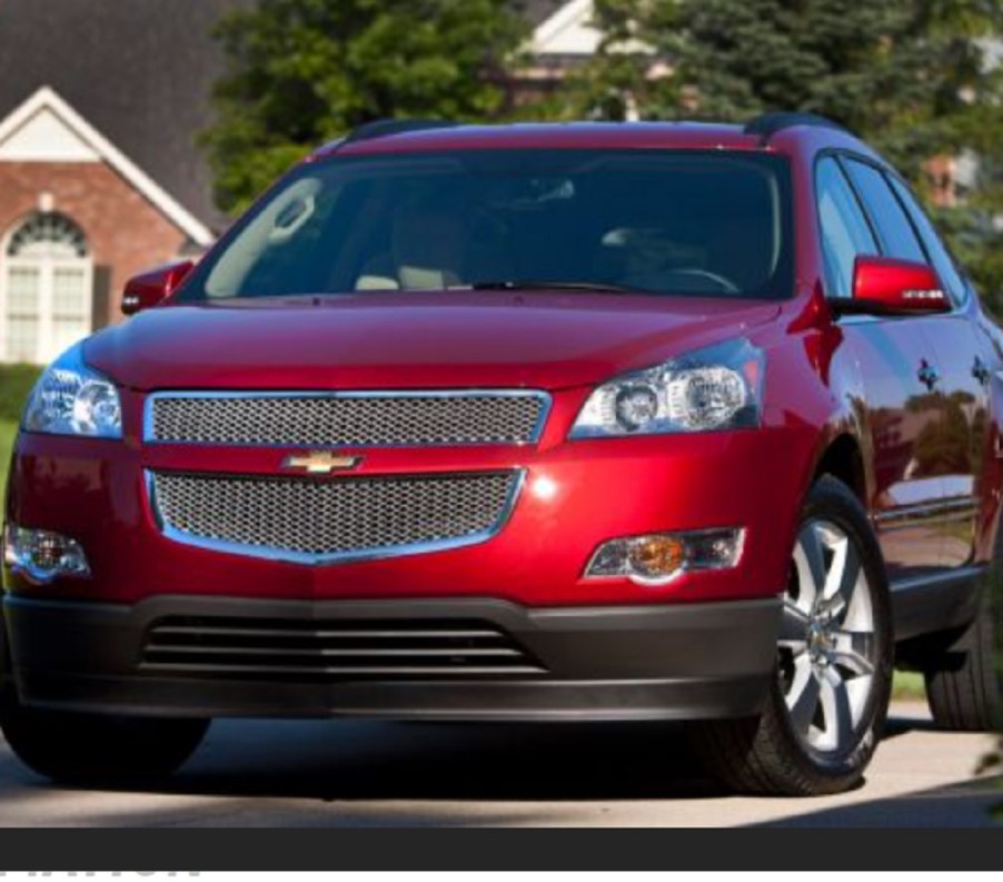 A red 2012 Chevy Traverse parked in a neighborhood.