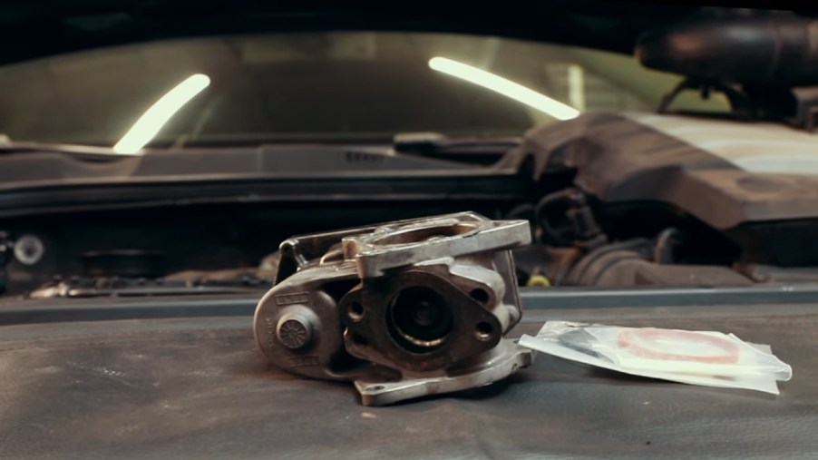 A dirty EGR valve resting atop a car