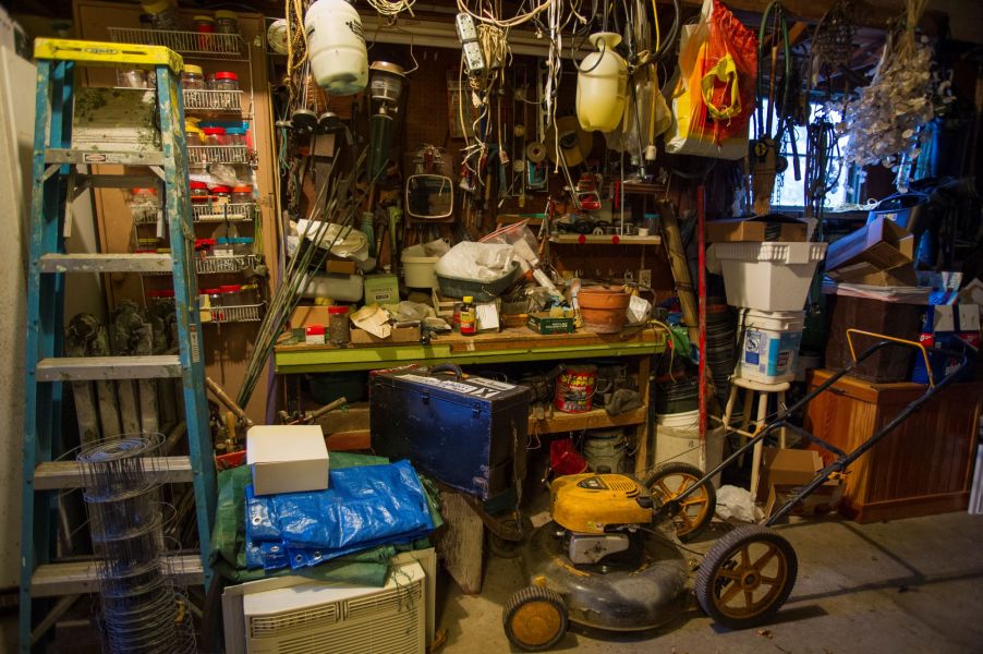 A silver lawn mower in storage in a garage