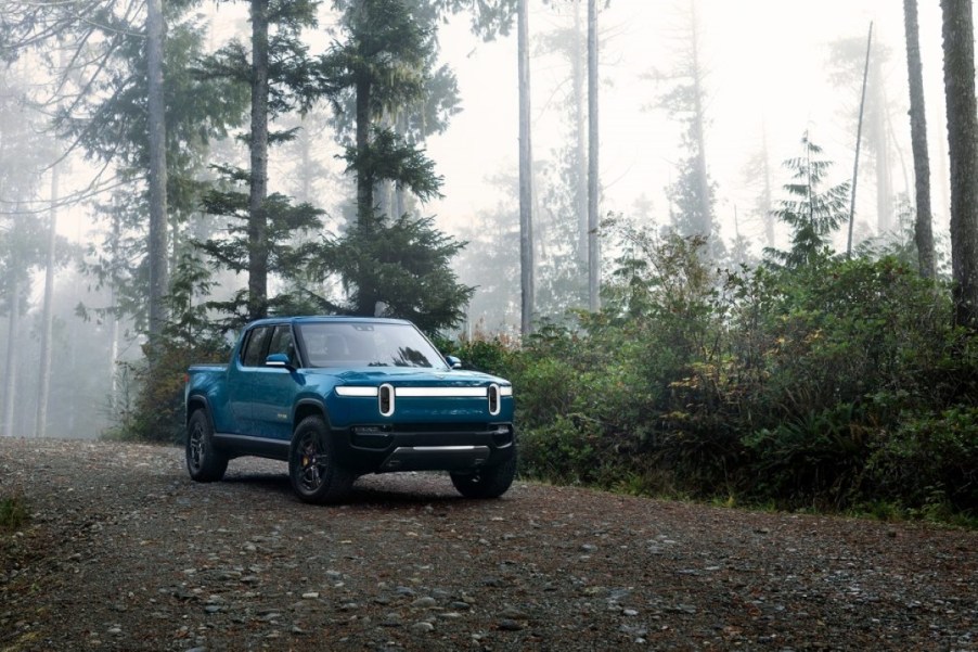 Blue Rivian R1T parked in a forest