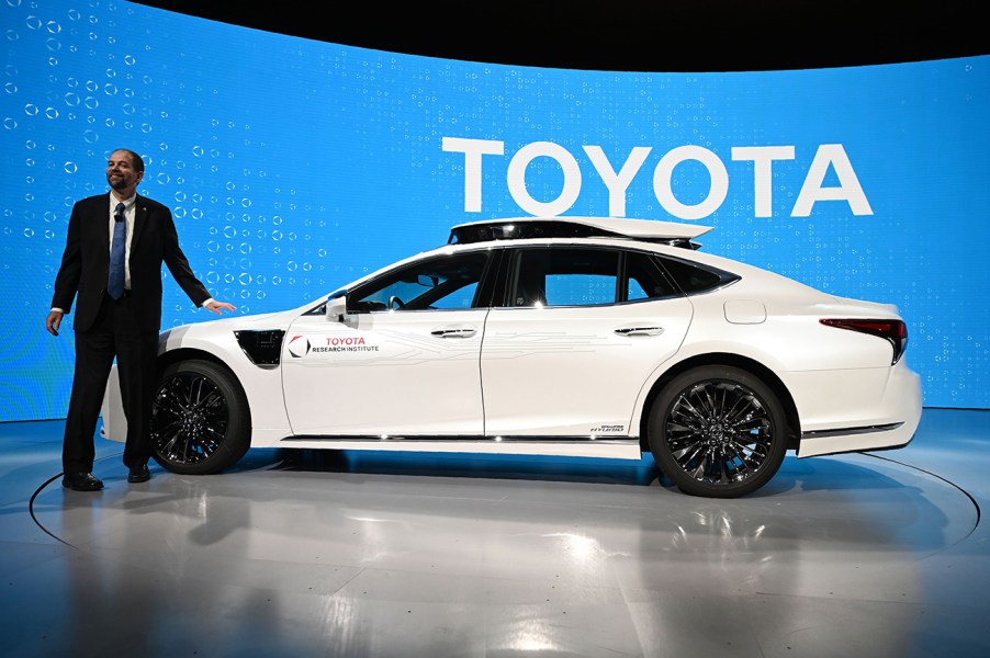 Chief Scientist of Toyota Motor Corp Gill Pratt standing next to a white Toyota autonomous vehicle. Pratt recently made comments that battery electric vehicles may not be for everyone