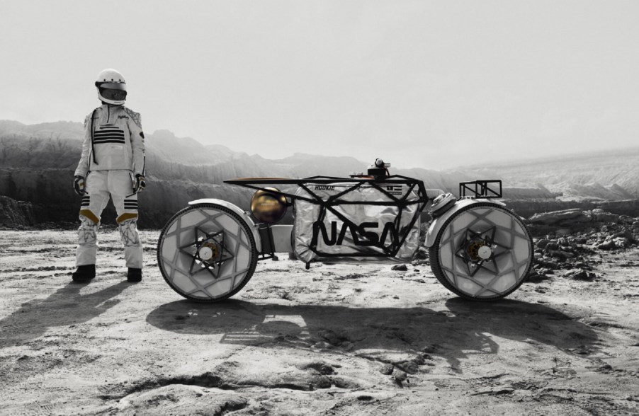 A white-clade rider next to the Hookie Co. Tardigrade in a Moon-like landscape