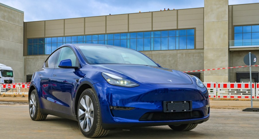 A blue Tesla model Y is parked.