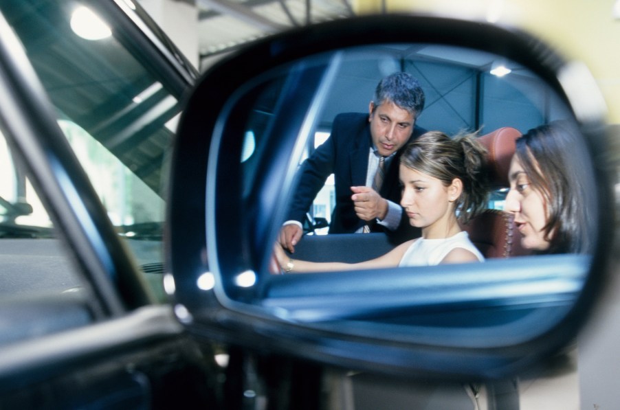 Two ladies learn about the Audi TT from a car salesperson