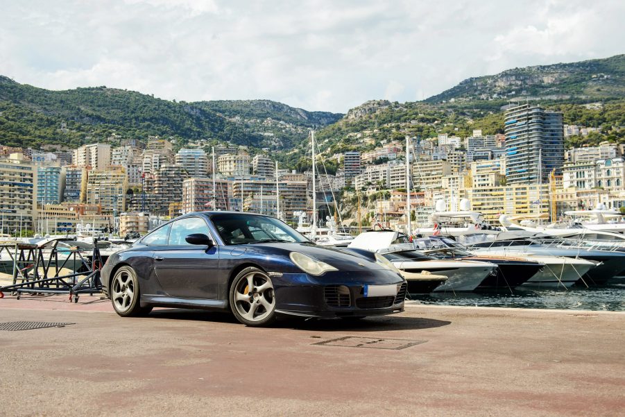 A dark blue 996 Porsche 911 on the docks in Monaco, shot from the 3/4 angle