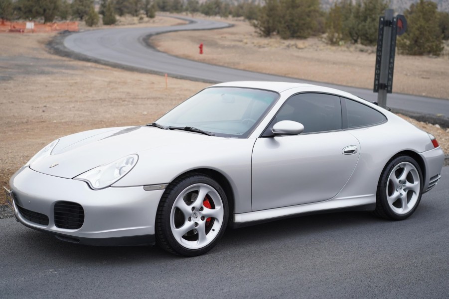 A silver 2003 Porsche 911 Carrera 4S parked by a winding road