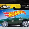 The side view of the green 'Ain't No Saint' 1969 Volvo P1800 gasser in front of a Hot Wheels Legends Tour sign