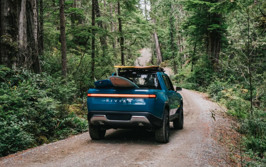 Blue Rivian R1T driving on a forest road