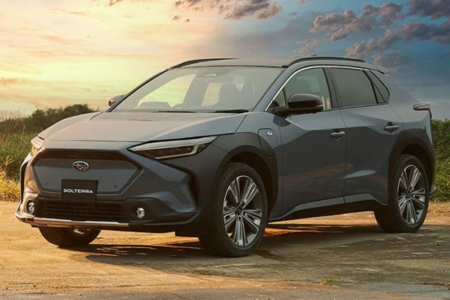 Blue-gray 2023 Subaru Solterra EV parked near a field, for information on release date, price, and specs