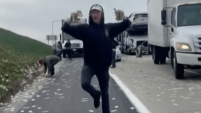 Man running with cash after armored truck rained money on a Califorina highway