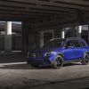 A 2021 Mercedes-Benz AMG GLB SUV with a blue paint color option parked under a concrete highway overpass