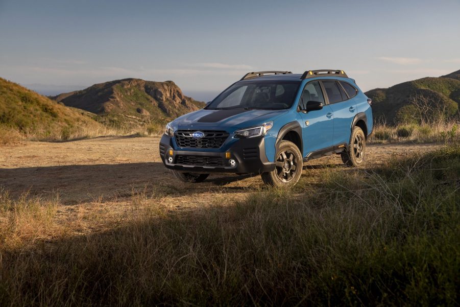 A blue 2022 Subaru Outback Wilderness wagon shot on a dirt road from the 3/4 angle