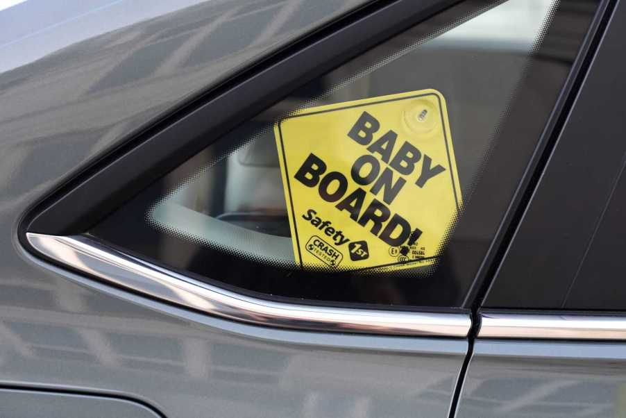 Baby on Board sign hanging from a car window