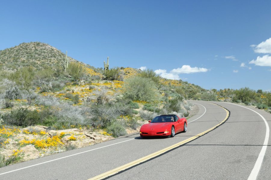 A red C5 Chevrolet Corvette sports car on a back road