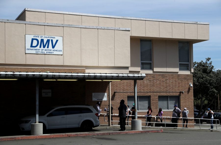 People waiting in line at the DMV. Make sure you research how to replace a lost car title before waiting in line.