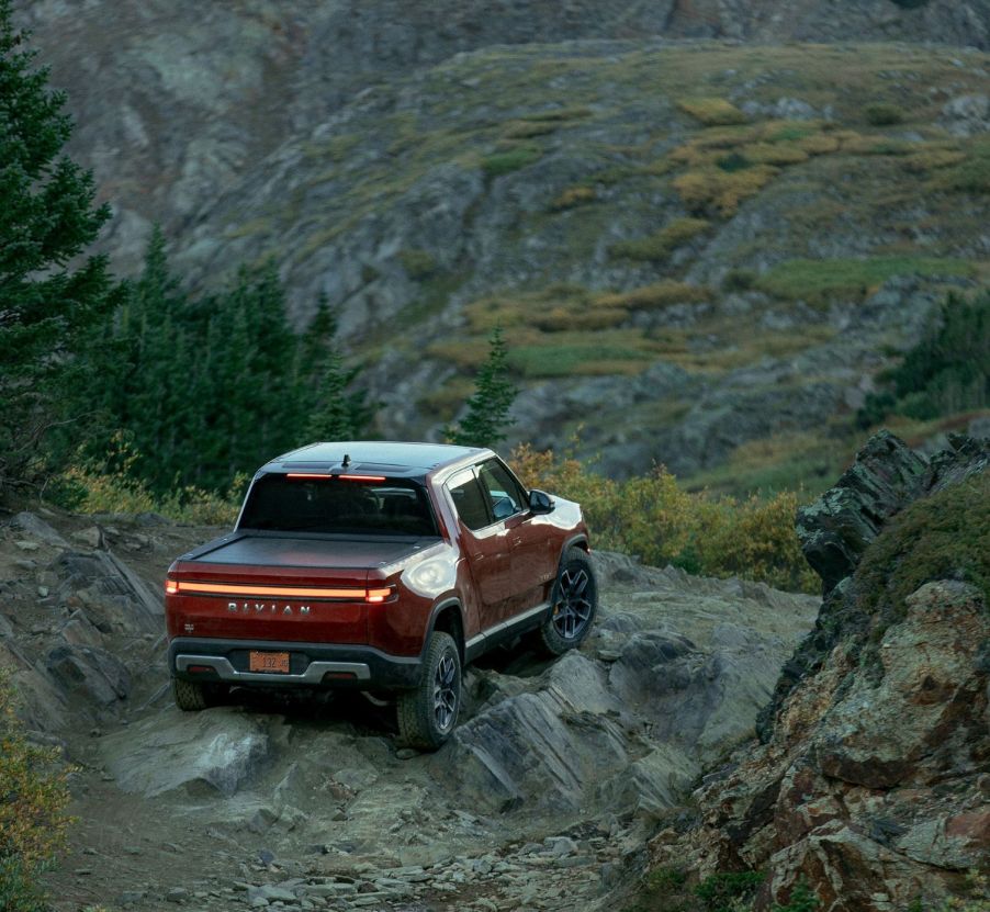 Red Canyon 2022 Rivian R1T parked on a rocky cliff, showing off its advantage over other EV trucks