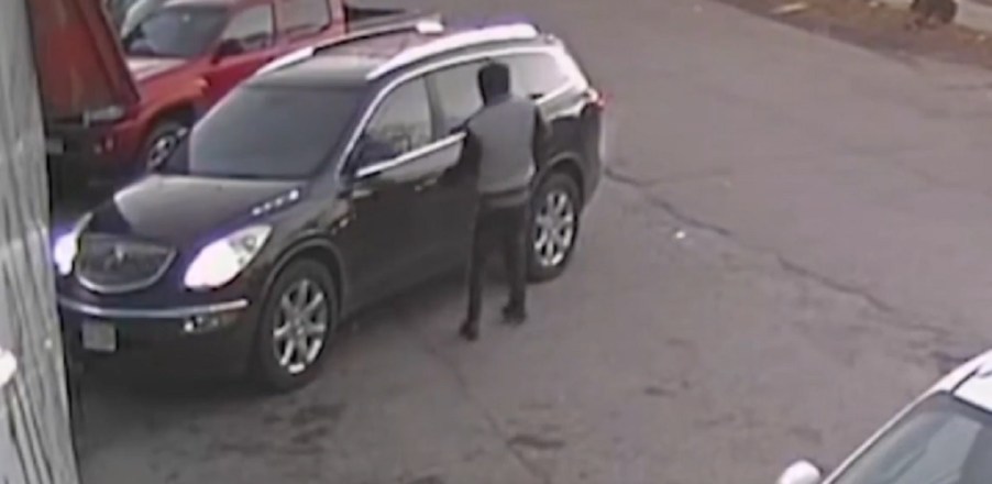 A teenager getting into a Buick Enclave.