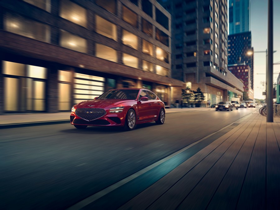 A red 2022 Genesis G70 shot from the front 3/4 on a city street