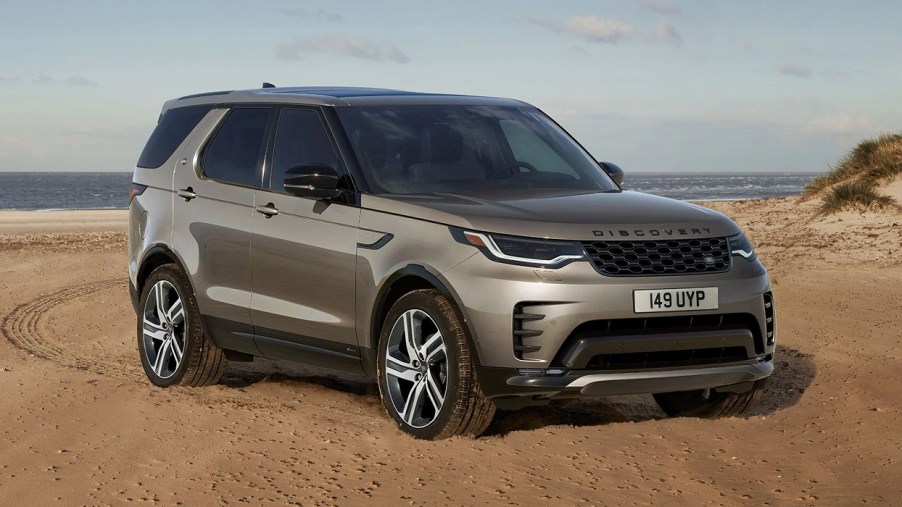 A gold 2022 Land Rover Discovery parked on sand.